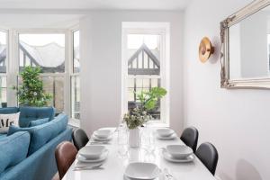 een eetkamer met een tafel en een blauwe bank bij 3 Bed, sea views, central Penzance,newly renovated in Penzance