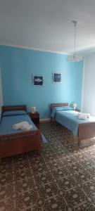 1 dormitorio con 2 camas y luz azul en Mom's House Casa Caterina, en Santa Caterina