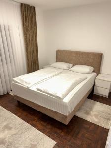 una camera da letto con un grande letto con lenzuola bianche di Apartment Paradise Enver a Dubrave Gornje
