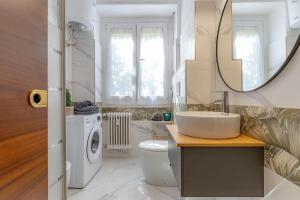 uma casa de banho com um lavatório, um WC e um espelho. em [Rio's] cozy apartment in the heart of Como em Como
