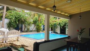 a patio with a swimming pool with a table and chairs at The river lake villa in Unawatuna