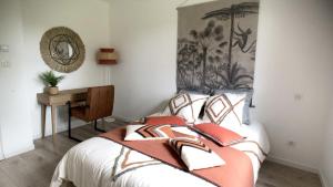 Schlafzimmer mit einem Bett mit einem Spiegel und einem Schreibtisch in der Unterkunft Maison moderne et écologique in Varaire
