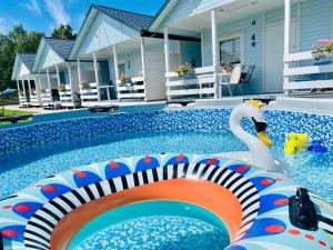 a pool with a pool noodle in front of a house at Domki Kapitana in Bobolin