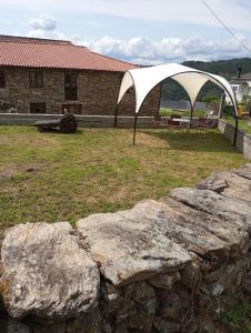 uma tenda branca num quintal com algumas pedras em Balcón san Lorenzo em Cristosende