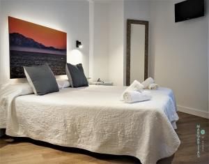um quarto com 2 camas e toalhas em Margaritas 21 Rooms em Tarifa