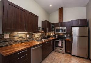 una cocina con armarios de madera y electrodomésticos de acero inoxidable en The best 2 bedrooms suite in Revelstoke! en Revelstoke