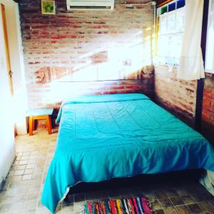 a bed in a room with a brick wall at TENDERETE in Villa General Belgrano
