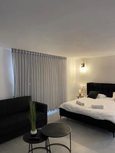 1 dormitorio con 2 camas, sofá y mesa en K.suites סוויטות בוטיק en Bet Sheʼan