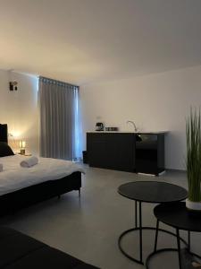 1 dormitorio con 1 cama y 2 mesas. en K.suites סוויטות בוטיק, en Beit She'an