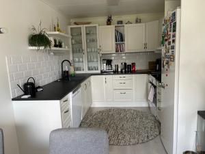 a kitchen with white cabinets and a black counter top at Leilighet med 2 soverom in Rokland