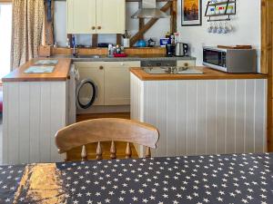 a kitchen with a counter and a table with a chair at The Lodge - Uk44556 in Plaistow