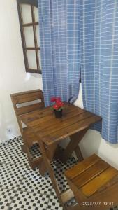Pousada João e Maria في ترينيداد: طاولة وكراسي خشبية عليها بوتقة
