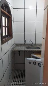 a small kitchen with a sink and a refrigerator at Pousada João e Maria in Trindade