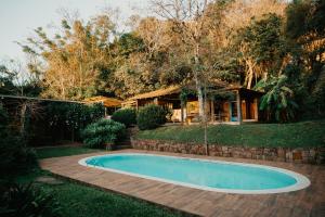 a swimming pool in the middle of a yard at Villa Tuiuty Pousada de Charme in Bento Gonçalves