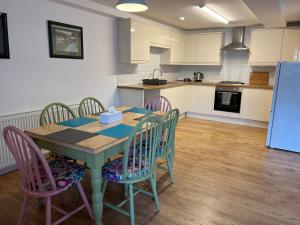 a kitchen with a table with chairs and a refrigerator at Beautiful Apartment,no 1, With Parking in Ilfracombe