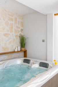 a bath tub with blue water in a room at Tonina apartment - house with patio, jacuzzi, free parking in Split