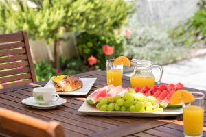 a wooden table with a plate of fruit and juice at Tonina apartment - house with patio, jacuzzi, free parking in Split