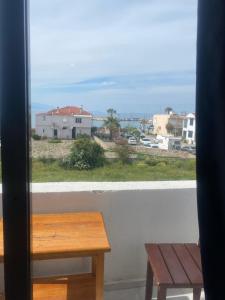 a window with a table and a bench on a balcony at Deniz Kızı Otel Çeşme in Çeşme