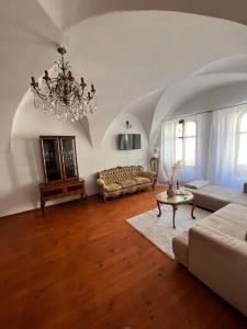 a living room with a couch and a chandelier at City Center Apartment in Banská Bystrica