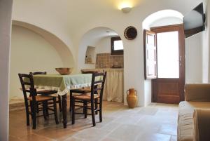 una cucina e una sala da pranzo con tavolo e sedie di Il Trullo del viaggiatore ad Alberobello
