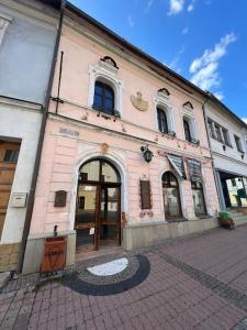 a pink building with a large door on a street at City Center Apartment in Banská Bystrica