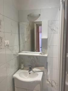 Baño blanco con lavabo y espejo en Villa Bougenvilia Tomas en Tučepi