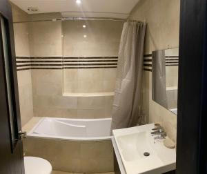 une petite salle de bain avec une baignoire et un lavabo dans l'établissement Aida village, à Tanger