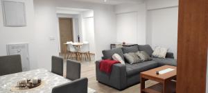 ein Wohnzimmer mit einem grauen Sofa und einem Tisch in der Unterkunft El Mirador de Gijón- piso 3 habitaciones excelente ubicación para moverse por Asturias-6 pax- in Gijón