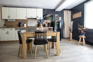a kitchen with a wooden table and chairs at COCOONING SPA - Gîte avec piscine, jacuzzi, sauna in Marck
