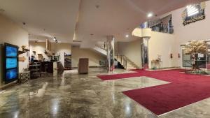 eine große Lobby mit rotem Teppich und Treppe in der Unterkunft تـرامونتـان للشقق المخدومة in Ha'il