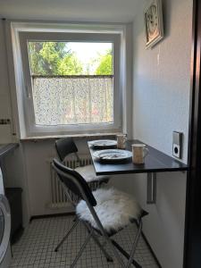 una mesa y una silla en una habitación con ventana en Apartment im Gründle, en Birkenfeld