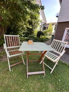 stół piknikowy i dwa krzesła siedzące obok domu w obiekcie Apartment im Gründle w mieście Birkenfeld