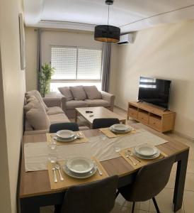 un salon avec une table avec des chaises et un canapé dans l'établissement Aida village, à Tanger
