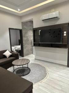 a living room with a couch and a flat screen tv at Cast Home in Ahad Rafidah