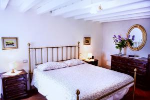 a bedroom with a bed and two dressers and a mirror at Bioagriturismo Podere Montisi in Calenzano