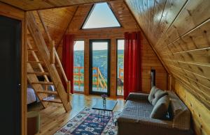 a living room with a couch and a large window at Panorama Dashbashi - Hotel in Dashbashi