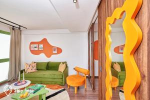 sala de estar con sofá verde y cinta amarilla en Stayhere Casablanca - CIL - Vibrant Residence, en Casablanca