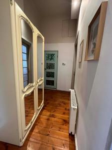 um corredor com um espelho grande e uma porta em H. Kloss Rooms em Lódź