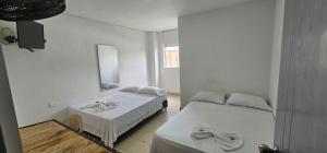 1 dormitorio con 2 camas y espejo en Hotel Bayadera Real en Medellín