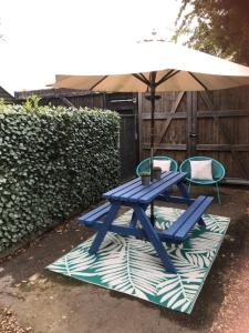 a picnic table and two chairs under an umbrella at The Studio in Newmarket