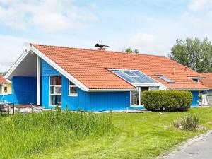 een blauw huis met een oranje dak en zonnepanelen bij 12 person holiday home in Otterndorf in Otterndorf