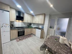 uma cozinha com uma mesa e um frigorífico branco em Appartement entier em El Altet