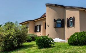 RupaStudio apartment Lu的前面有草地的房屋