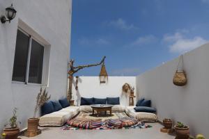 a living room with a couch and a table at Wavy Days Surf Lodge in Tamraght Ouzdar