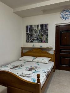 a bed in a bedroom with a picture on the wall at Apartman Stasija in Tivat