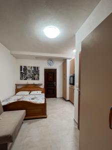 a small bedroom with a bed and a kitchen at Apartman Stasija in Tivat