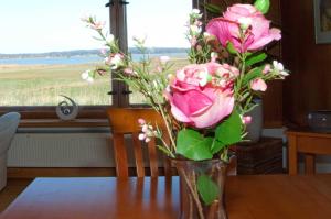 オストゼーバート・ゼリンにあるReethaus am Seeのテーブルに座るピンクのバラが詰まった花瓶