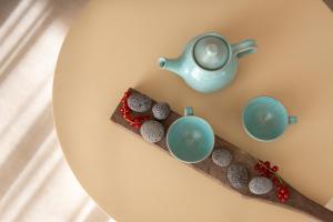 a plate with a tea pot and cupcakes on it at CeraMio Suites in Limenas