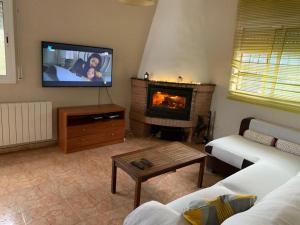 a living room with a fireplace and a flat screen tv at HappyHouse Pura vida in Mont Barbat