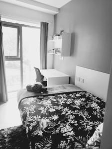 a bedroom with a bed with a black and white blanket at Studio apartment within city centre with ensuite in Coventry